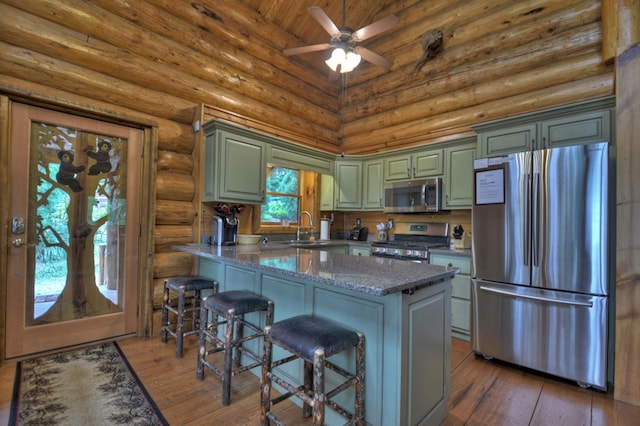 kitchen featuring a healthy amount of sunlight, stainless steel appliances, high vaulted ceiling, and dark wood-type flooring