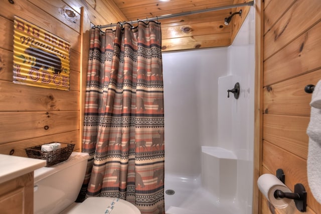 bathroom with walk in shower, toilet, wooden walls, and vanity