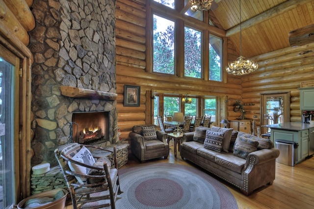 living room featuring an inviting chandelier, wood ceiling, a stone fireplace, rustic walls, and high vaulted ceiling