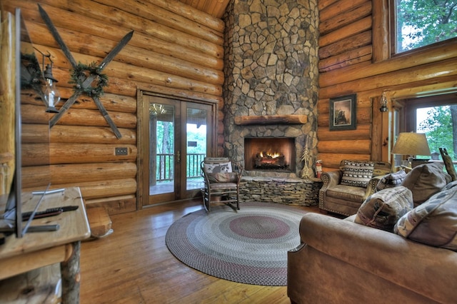 living room with high vaulted ceiling, wood-type flooring, log walls, and a stone fireplace