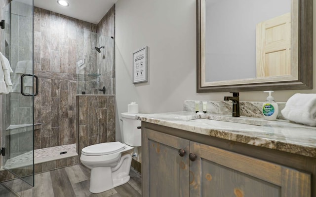 bathroom featuring hardwood / wood-style flooring, vanity, toilet, and an enclosed shower