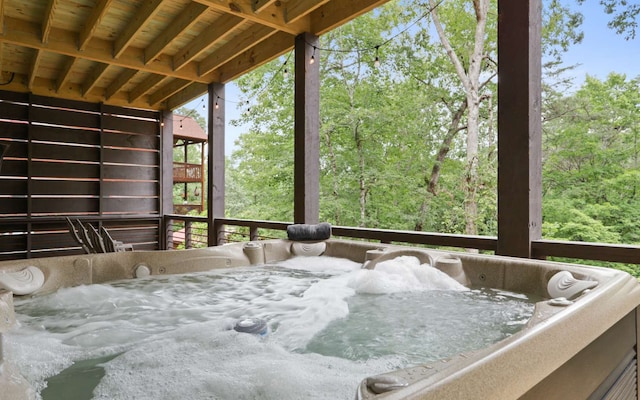 sunroom featuring wood ceiling, lofted ceiling with beams, and a hot tub