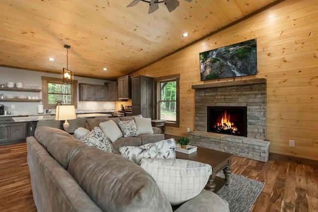 living room featuring wood ceiling, vaulted ceiling, dark hardwood / wood-style floors, a stone fireplace, and wood walls