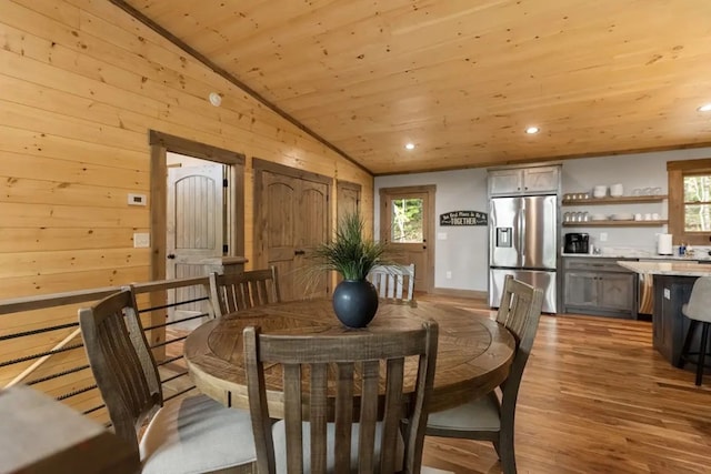 dining room with wooden ceiling, a healthy amount of sunlight, light hardwood / wood-style floors, and vaulted ceiling