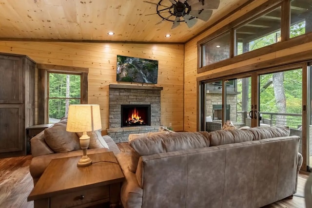 living room featuring light wood-type flooring, a wealth of natural light, and wood walls