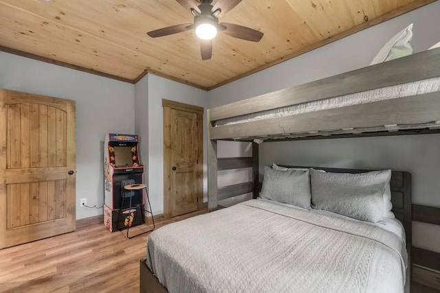 bedroom featuring ceiling fan, light wood-type flooring, ornamental molding, and wooden ceiling