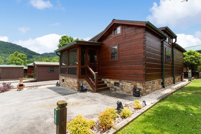 106 River Vista Dr, Dillard, GA 30537 - view of front facade with a sunroom, a mountain view, a patio, and driveway