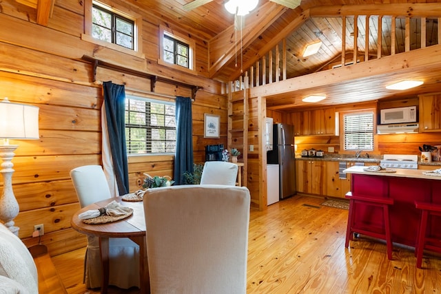 106 River Vista Dr, Dillard, GA 30537 - dining room featuring wood walls, plenty of natural light, high vaulted ceiling, a wood ceiling with exposed beams, and light wood-style flooring