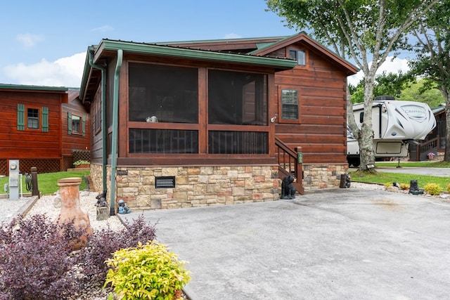106 River Vista Dr, Dillard, GA 30537 - view of side of home featuring a sunroom and stone siding