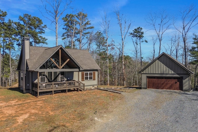 rustic home featuring a porch, driveway, a chimney, board and batten siding, and a shingled roof
