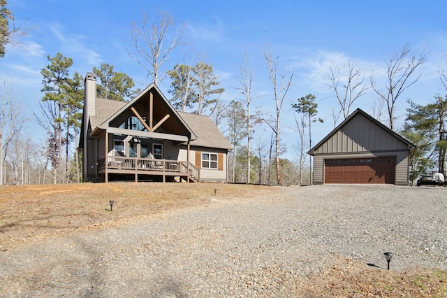 view of front of home with a porch, a chimney, a garage, gravel driveway, and board and batten siding