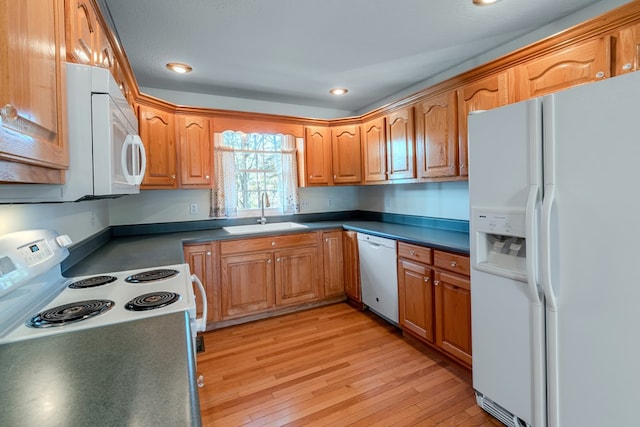 kitchen featuring white appliances, light hardwood / wood-style floors, and sink