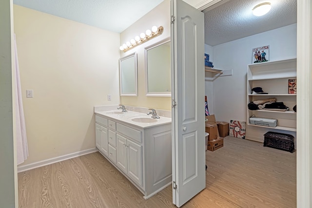 bathroom featuring vanity, a textured ceiling, and hardwood / wood-style flooring