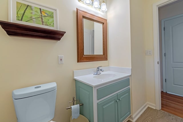 bathroom with vanity, toilet, and wood-type flooring