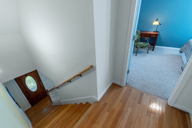 stairway featuring hardwood / wood-style floors and lofted ceiling