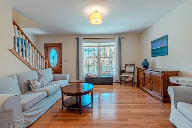 living room with a textured ceiling and light hardwood / wood-style flooring