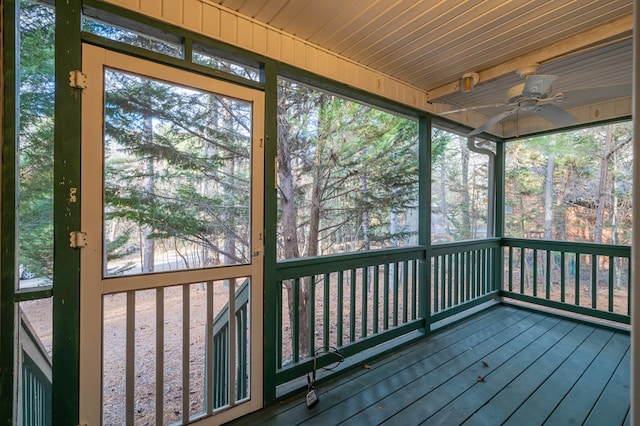 unfurnished sunroom with wood ceiling, ceiling fan, and a healthy amount of sunlight