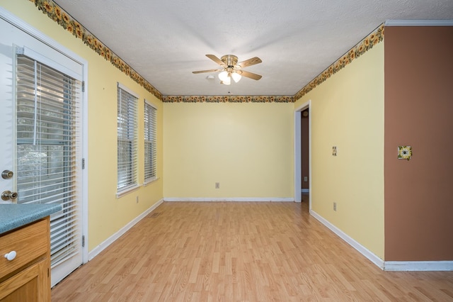 spare room with ceiling fan, light hardwood / wood-style floors, and a textured ceiling