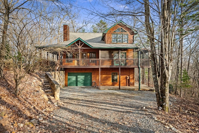 back of house featuring a wooden deck and a garage