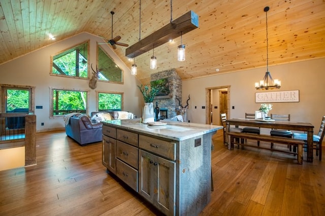 kitchen featuring a center island, light hardwood / wood-style flooring, hanging light fixtures, wood ceiling, and high vaulted ceiling