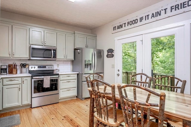 104 E Buck Run, Dahlonega, GA 30533 - kitchen with appliances with stainless steel finishes, backsplash, light wood-type flooring, light countertops, and gray cabinetry