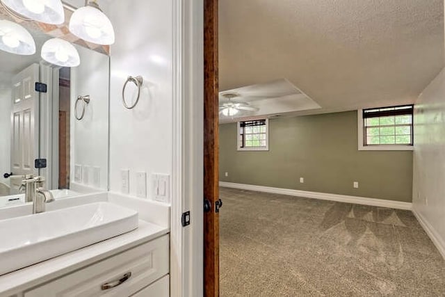 bathroom featuring ceiling fan, plenty of natural light, vanity, and a textured ceiling