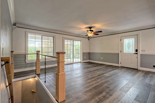 unfurnished living room featuring crown molding, ceiling fan, and dark wood-type flooring