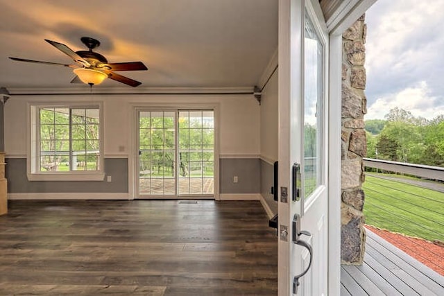 interior space with ceiling fan, crown molding, and dark wood-type flooring