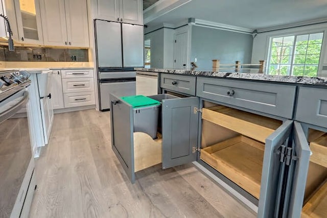 kitchen with gray cabinetry, white cabinets, dishwasher, fridge, and stainless steel range