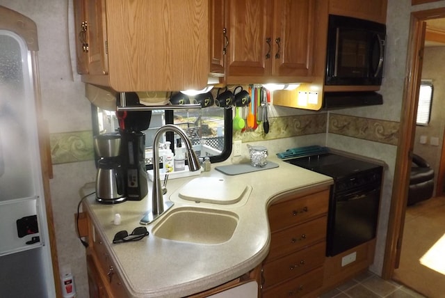 kitchen featuring tile patterned flooring, sink, and black appliances