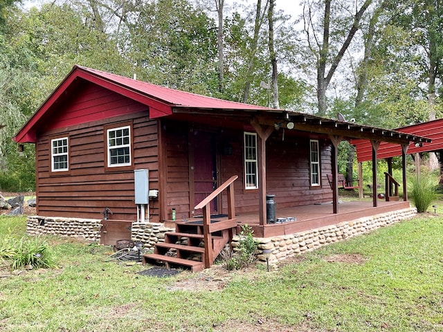 back of property featuring metal roof and a yard