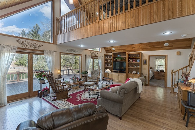 living room with a towering ceiling and light wood-type flooring