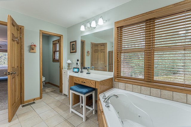 bathroom with vanity, a tub, tile patterned floors, and toilet