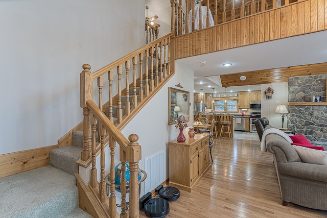 stairs featuring wood-type flooring and a towering ceiling