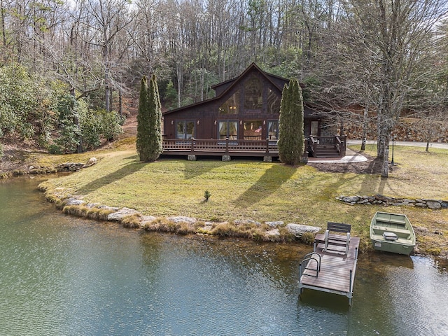 back of property featuring a deck with water view and a lawn