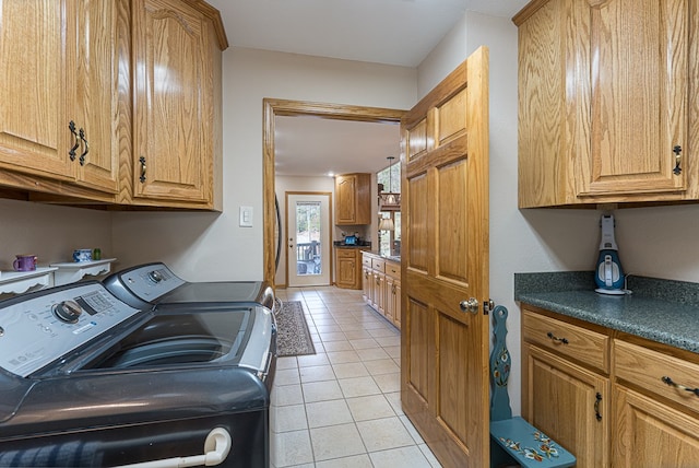 laundry area featuring cabinets, light tile patterned floors, and independent washer and dryer