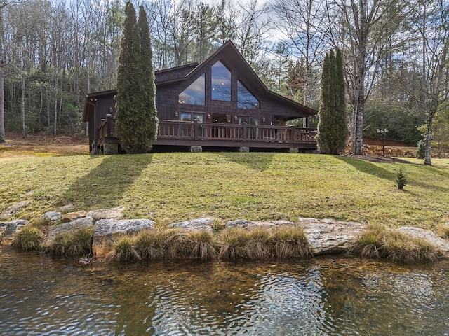 back of house with a deck with water view and a yard