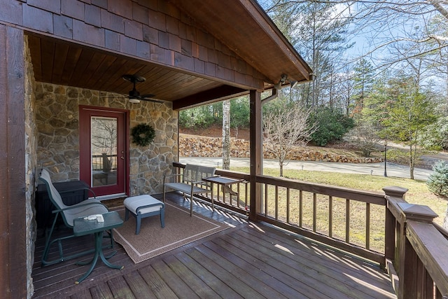 wooden terrace with ceiling fan and a yard