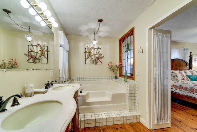 1504 Red Marble Rd, Andrews, NC 28901 - bathroom with ensuite bathroom, wood finished floors, a bath, double vanity, and a textured ceiling