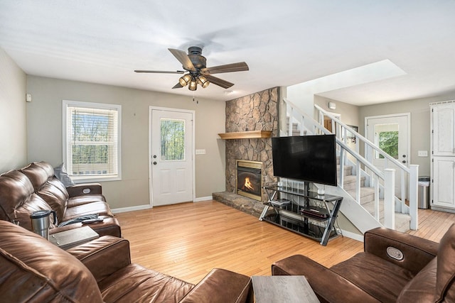 542 Sharp Top Cir, Blairsville, GA 30512 - living room featuring light wood-type flooring, a stone fireplace, stairs, and a healthy amount of sunlight
