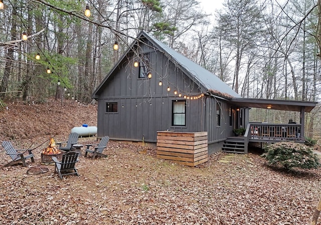 view of side of home with an outdoor fire pit and a wooden deck