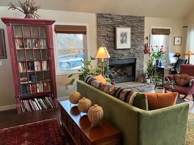 living room featuring vaulted ceiling, wood-type flooring, and a fireplace