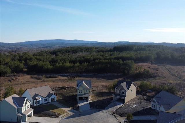 view of mountain background featuring a heavily wooded area