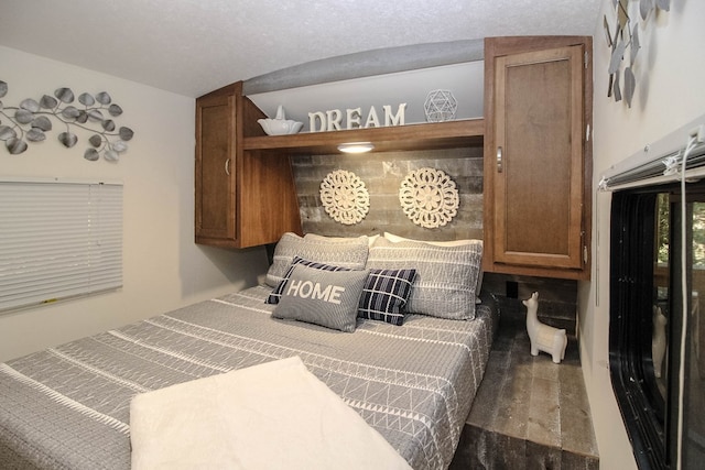 bedroom featuring a textured ceiling and vaulted ceiling