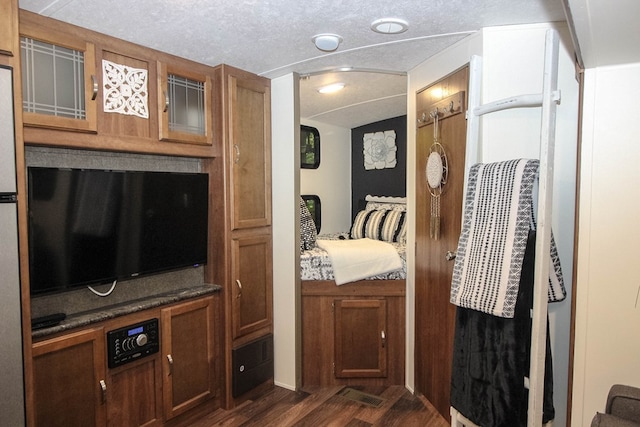 bedroom with a textured ceiling and dark hardwood / wood-style flooring