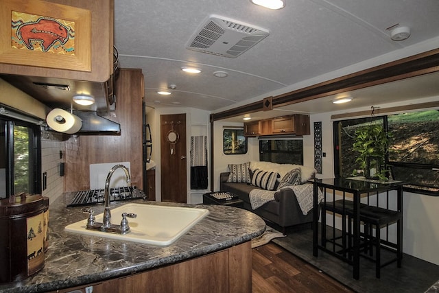 kitchen featuring sink, kitchen peninsula, dark hardwood / wood-style floors, and a textured ceiling