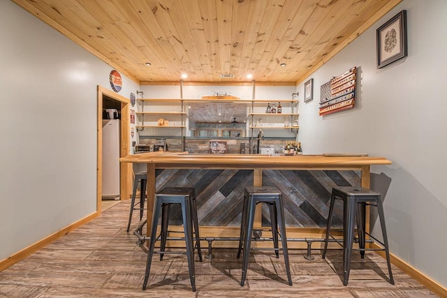 bar featuring light hardwood / wood-style flooring and wooden ceiling