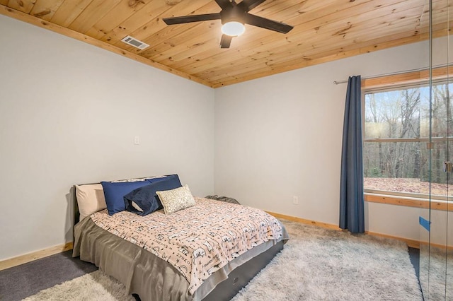 bedroom featuring ceiling fan, wooden ceiling, and dark colored carpet