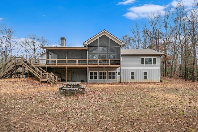 rear view of property featuring a sunroom and a deck