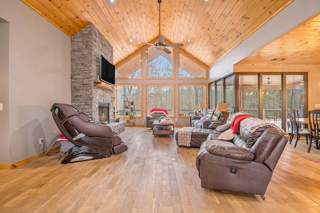 living room featuring a fireplace, light hardwood / wood-style floors, plenty of natural light, and ceiling fan